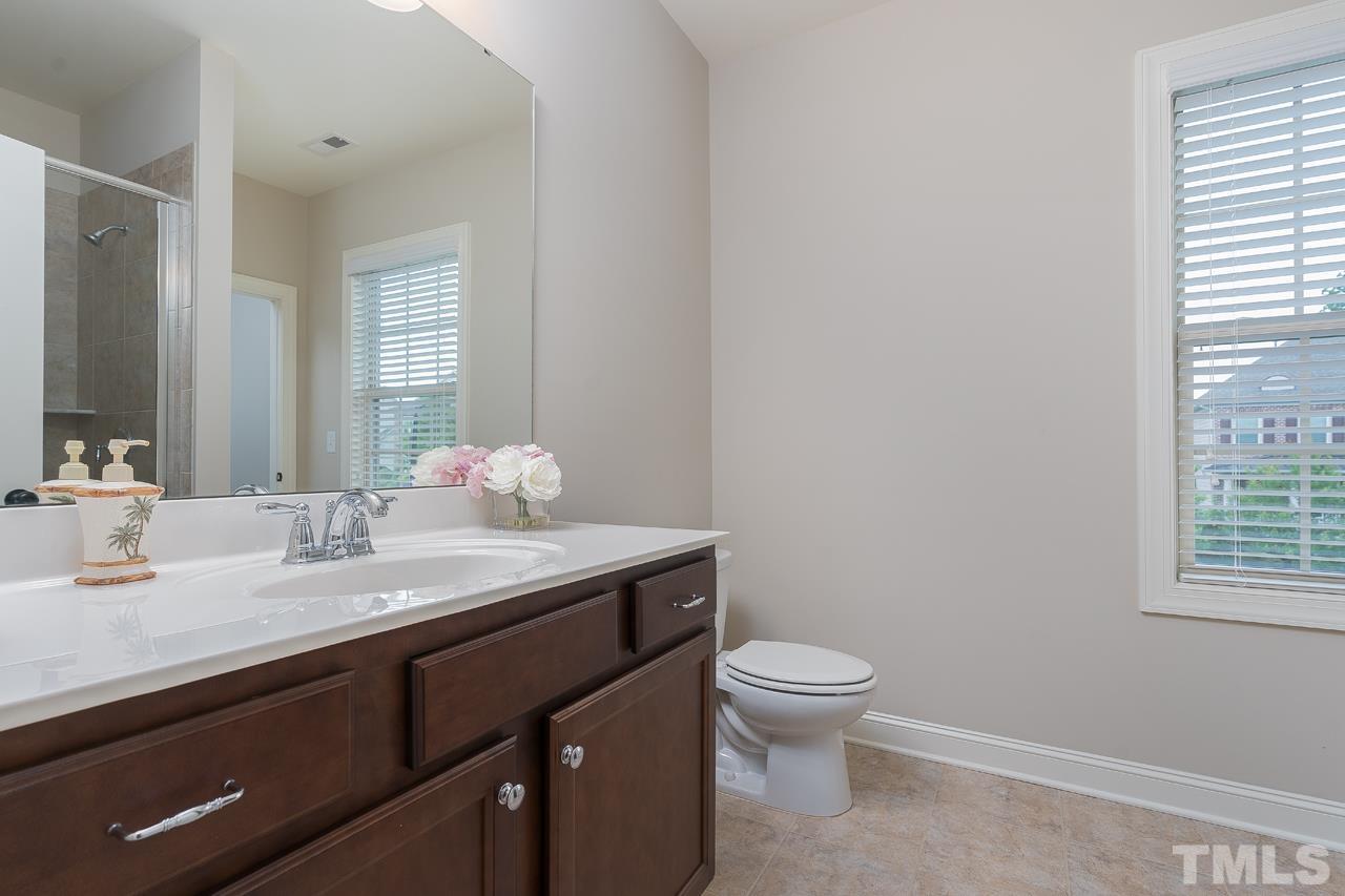 4813 Sunset Fairways Drive Apex, NC 27539 - Photo 29 of 44 a bathroom with a granite countertop sink a toilet and a mirror