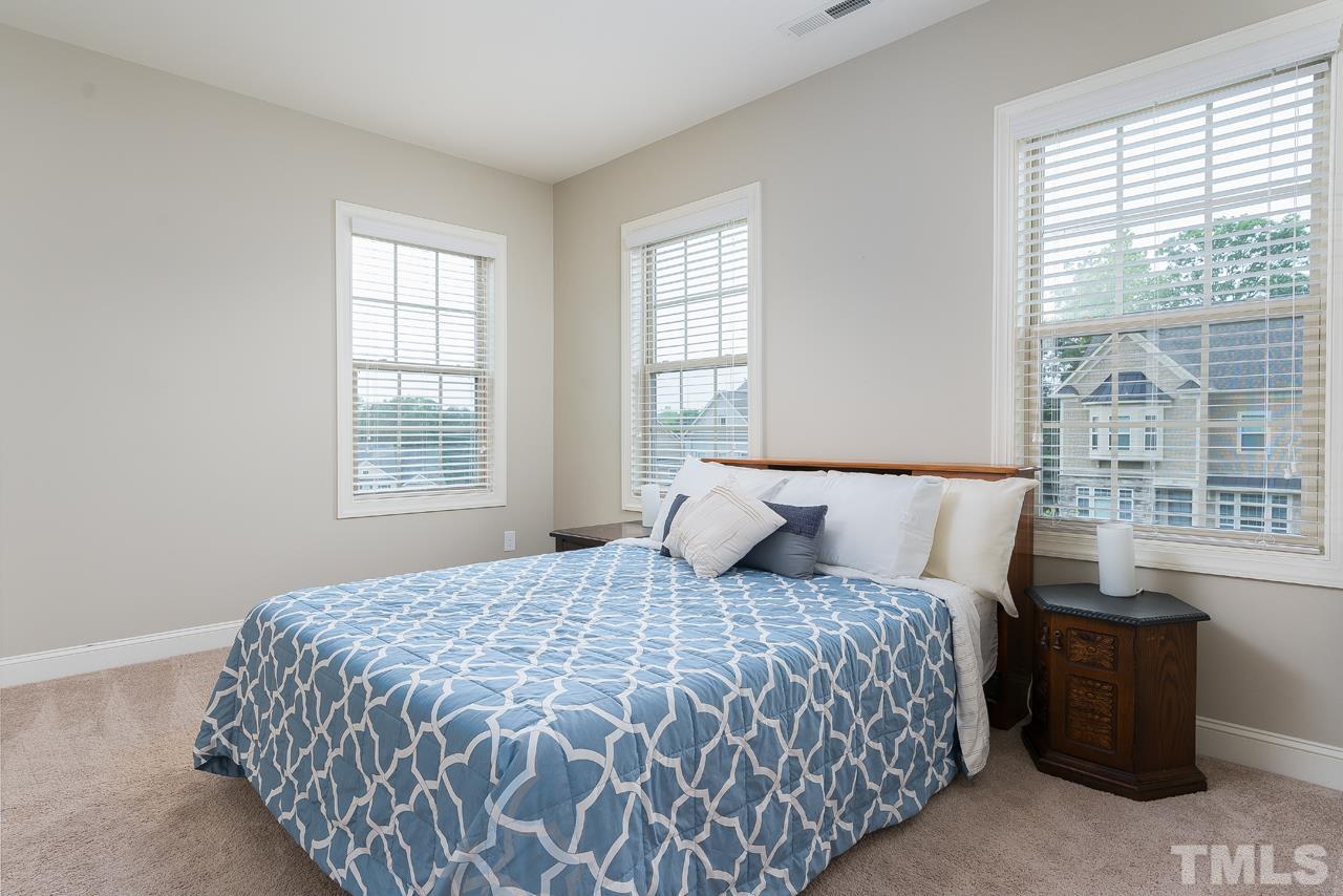 4813 Sunset Fairways Drive Apex, NC 27539 - Photo 31 of 44 a bedroom with a large bed and a window