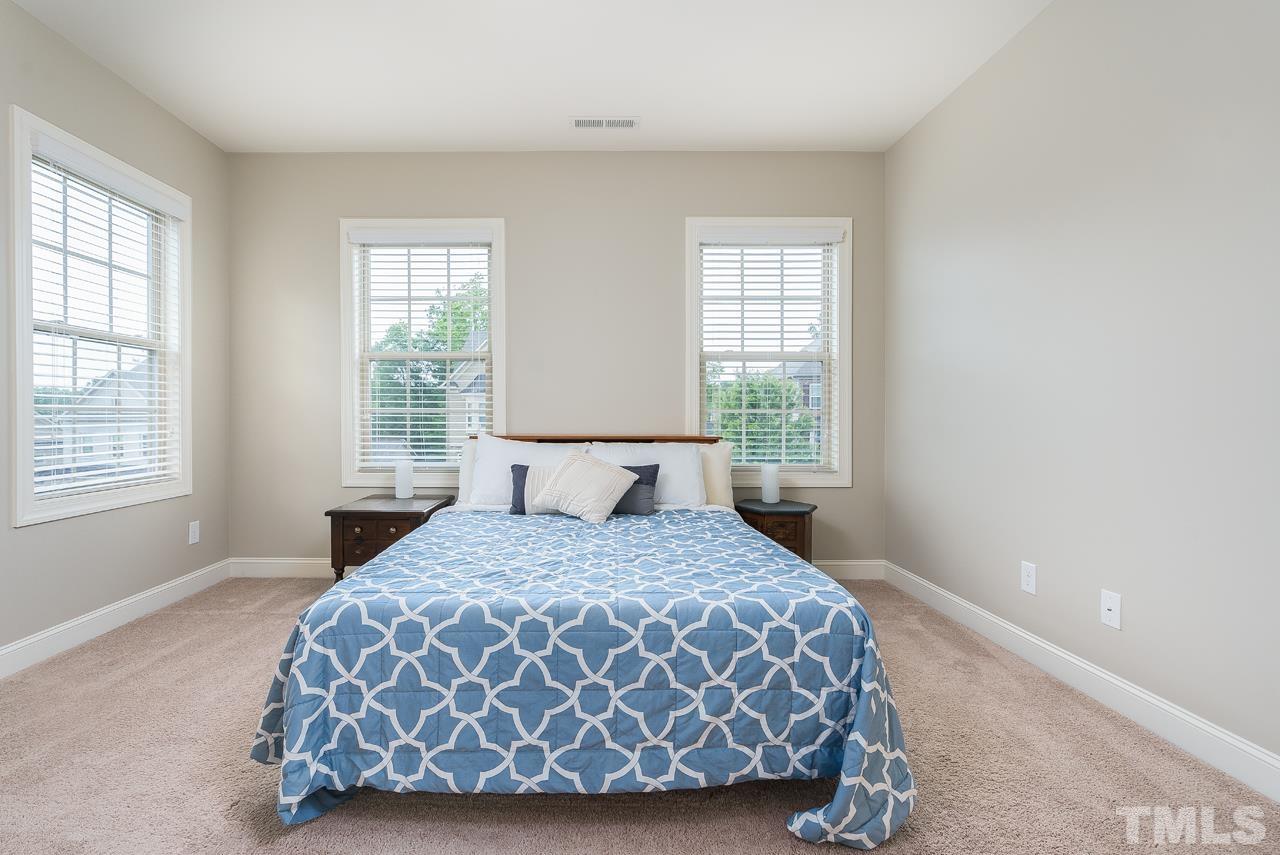 4813 Sunset Fairways Drive Apex, NC 27539 - Photo 32 of 44 a bedroom with a bed lamp and window