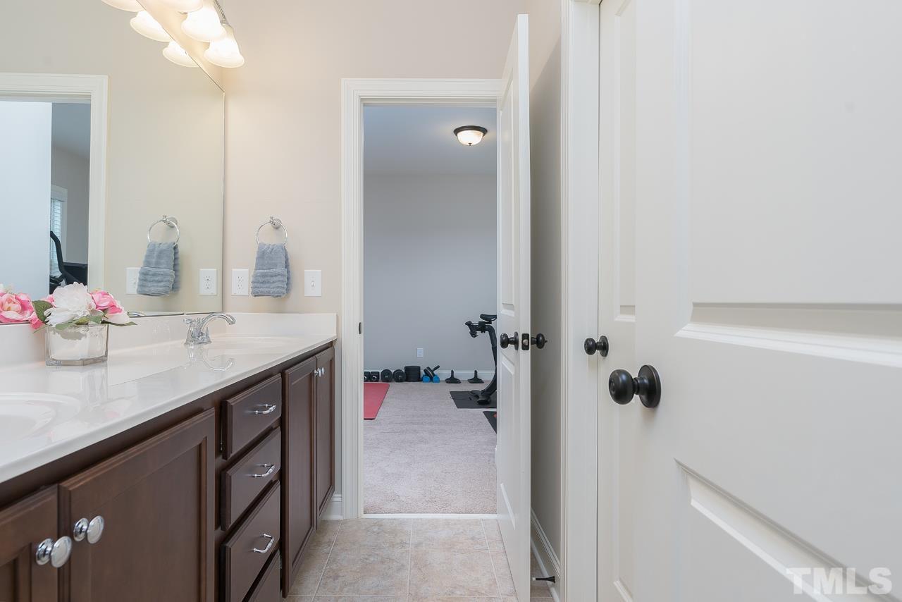 4813 Sunset Fairways Drive Apex, NC 27539 - Photo 34 of 44 a bathroom with a granite countertop sink a mirror and shower