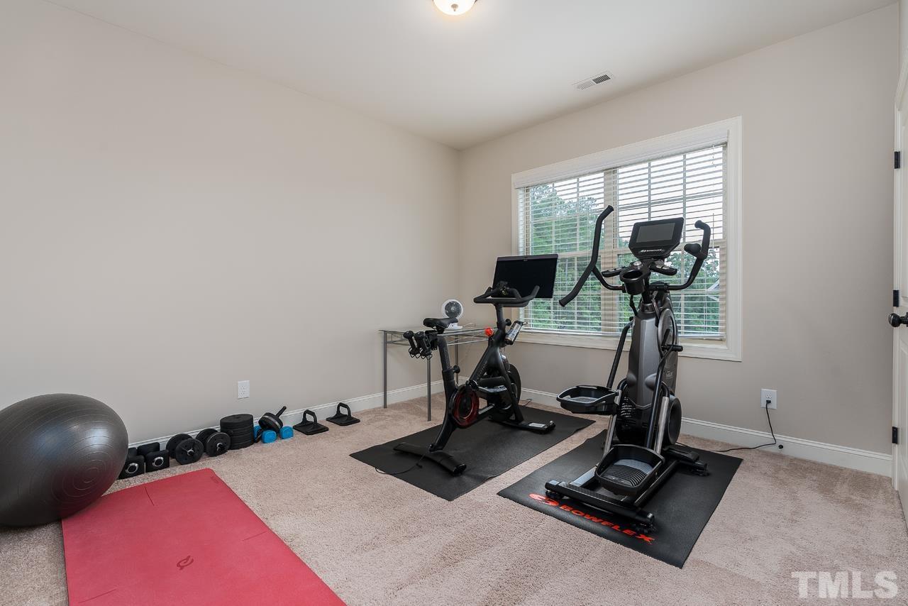 4813 Sunset Fairways Drive Apex, NC 27539 - Photo 35 of 44 a room with gym equipment and a view of living room