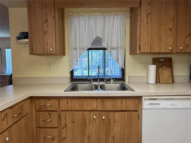 a kitchen with granite countertop a sink stove and cabinets
