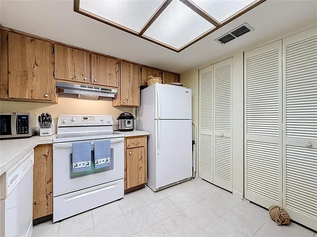 a kitchen with refrigerator and white cabinets