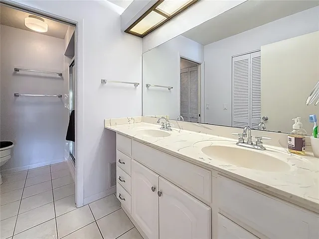 a bathroom with a double vanity sink toilet and a mirror