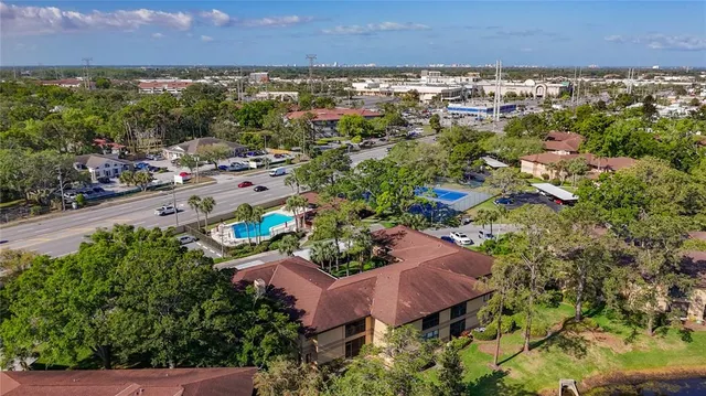 an aerial view of residential houses with outdoor space and trees