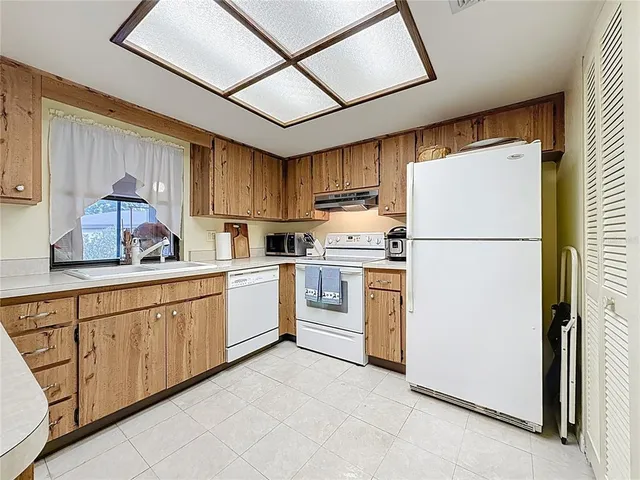 a kitchen with sink refrigerator and cabinets