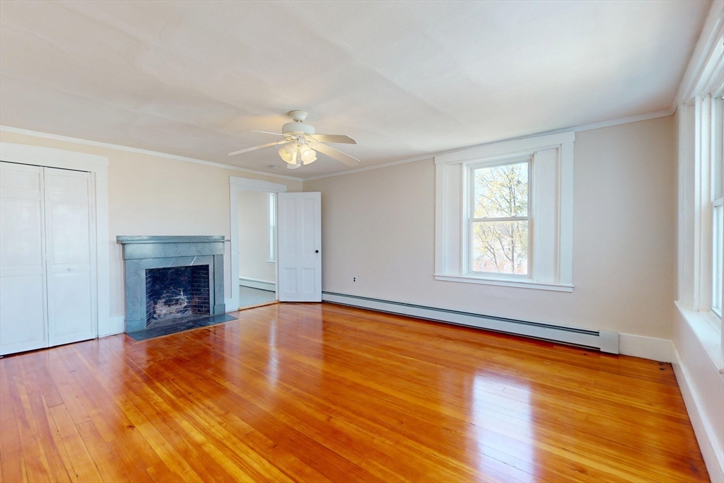 18 Faneuil Road, Unit 18 Waltham, MA 02452 - Photo 14 of 20 an empty room with a fireplace and wooden floor