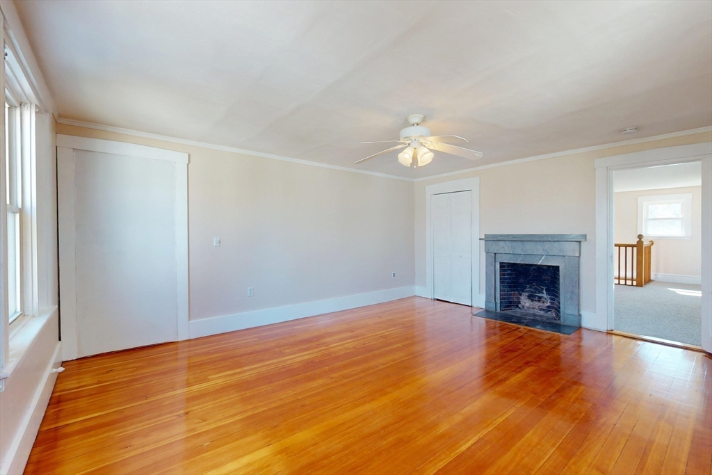 18 Faneuil Road, Unit 18 Waltham, MA 02452 - Photo 15 of 20 a view of an empty room with wooden floor fireplace and a window