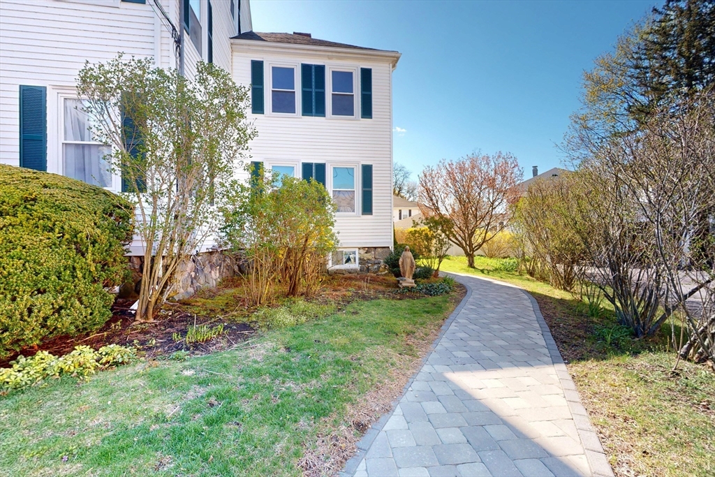 18 Faneuil Road, Unit 18 Waltham, MA 02452 - Photo 2 of 20 a view of a brick house with a yard and plants
