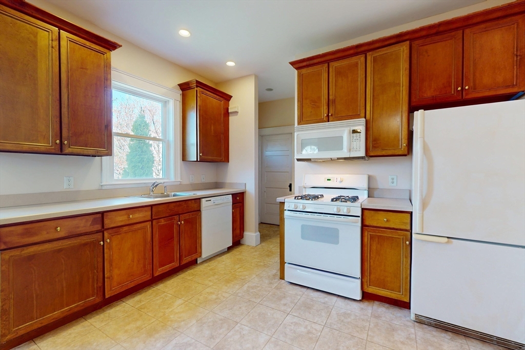18 Faneuil Road, Unit 18 Waltham, MA 02452 - Photo 6 of 20 a kitchen with stainless steel appliances granite countertop a stove a sink dishwasher and a refrigerator