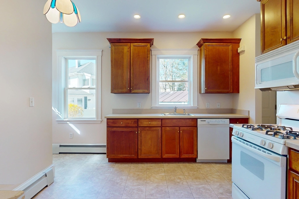 18 Faneuil Road, Unit 18 Waltham, MA 02452 - Photo 7 of 20 a kitchen with stainless steel appliances granite countertop a stove a sink and a refrigerator