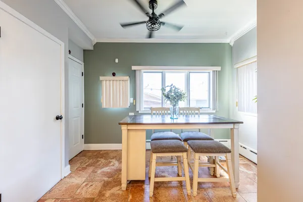 a kitchen with stainless steel appliances kitchen island granite countertop a table chairs and a refrigerator