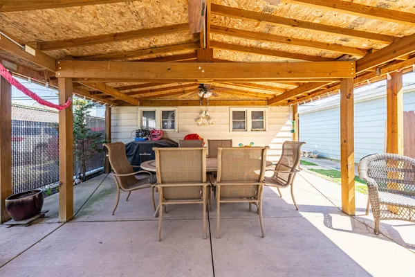a view of a patio with a table and chairs under an umbrella