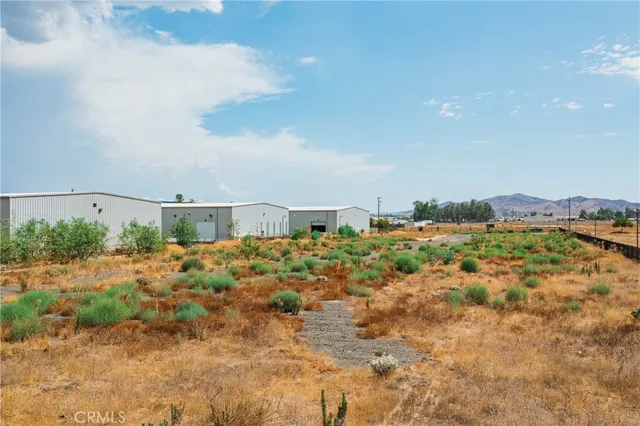 a view of a dry yard with wooden fence