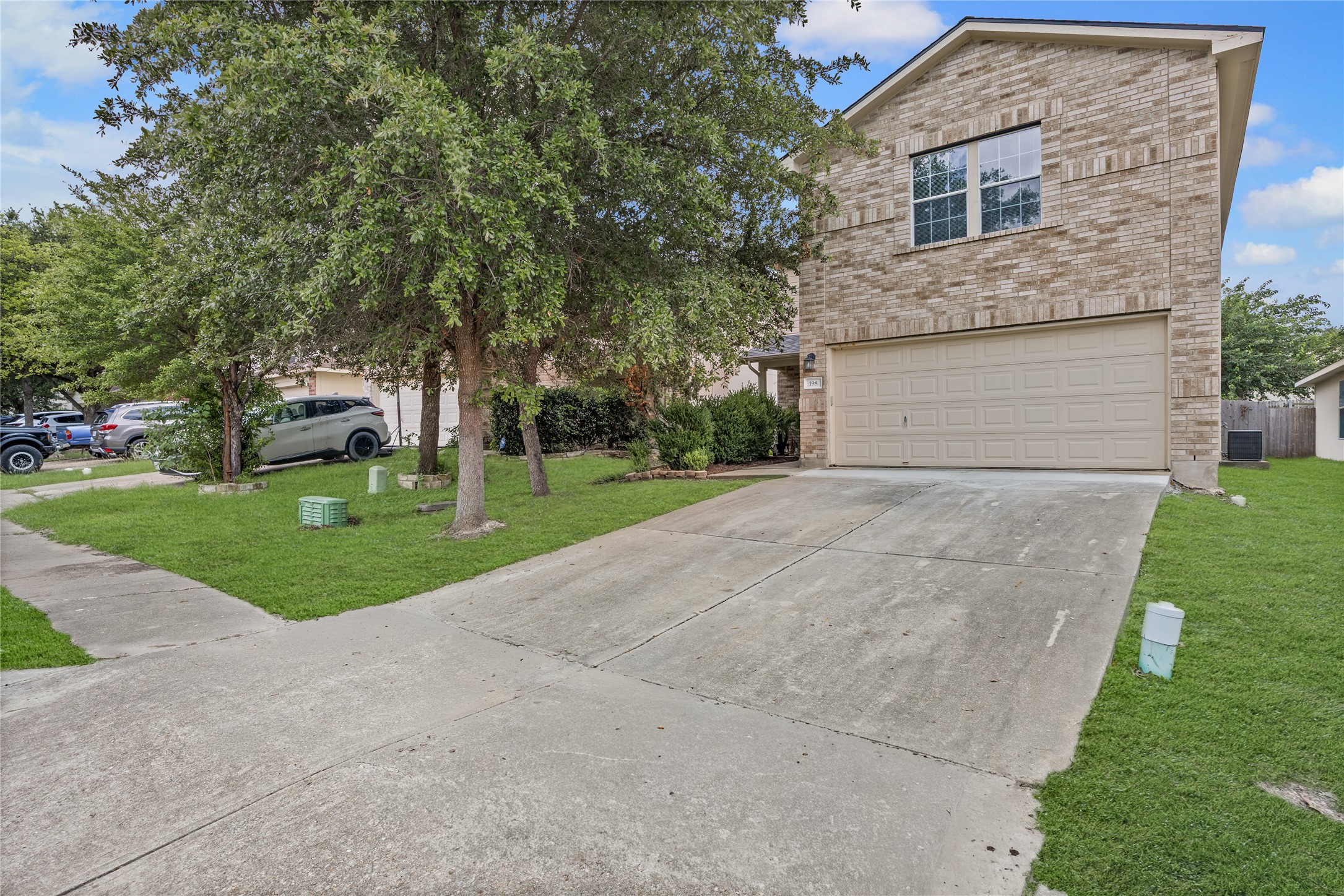 198 Black Forest Road Buda, TX 78610 - Photo 2 of 23 A classic brick exterior offers enduring curb appeal and a spacious driveway leading to the garage.