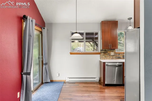 a kitchen with stainless steel appliances granite countertop a refrigerator a stove and a wooden floor