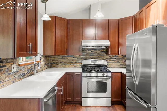 a kitchen with kitchen island granite countertop a sink appliances and cabinets