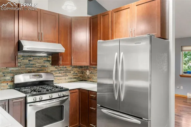 a kitchen with a refrigerator and a stove top oven
