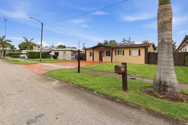 a front view of a house with a yard and fence