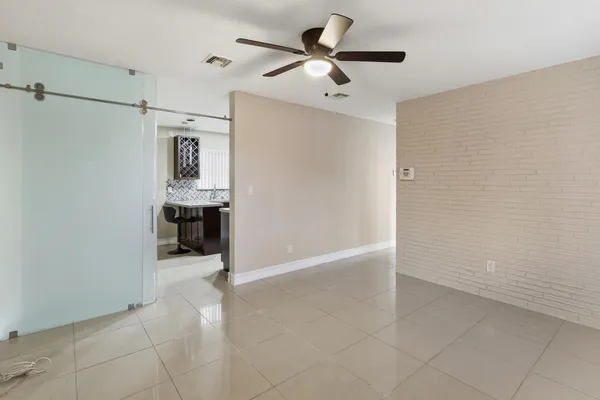 a view of an empty room with a ceiling fan and window