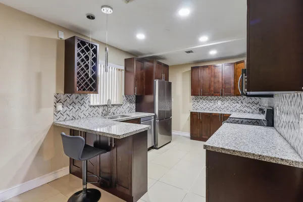 a kitchen with stainless steel appliances granite countertop wooden cabinets a sink and a stove