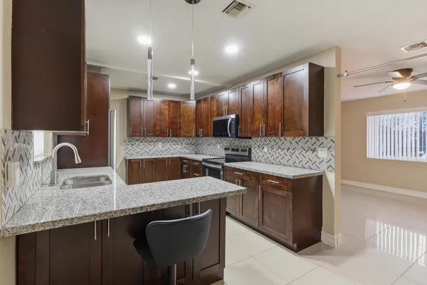 a kitchen with stainless steel appliances granite countertop a sink stove and refrigerator