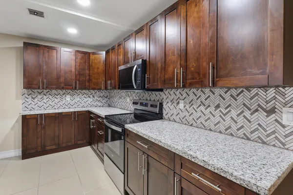 a kitchen with stainless steel appliances granite countertop a sink stove and cabinets