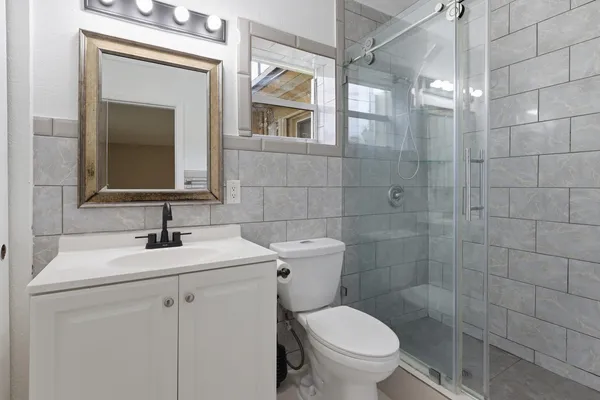 a bathroom with a sink a toilet and shower