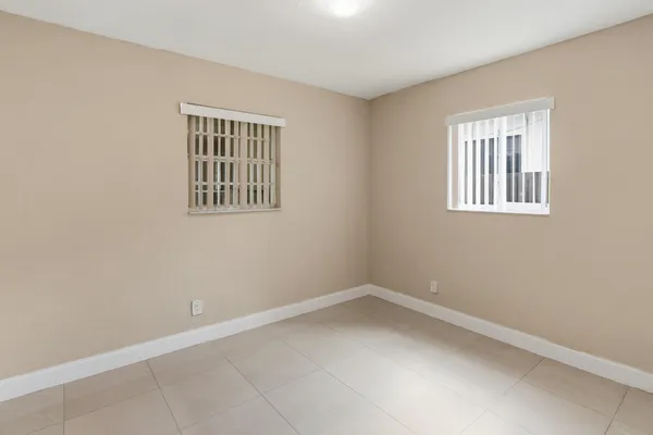 a view of an empty room with window and closet area