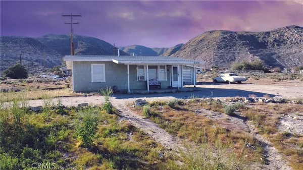 a view of a house with a yard and mountain