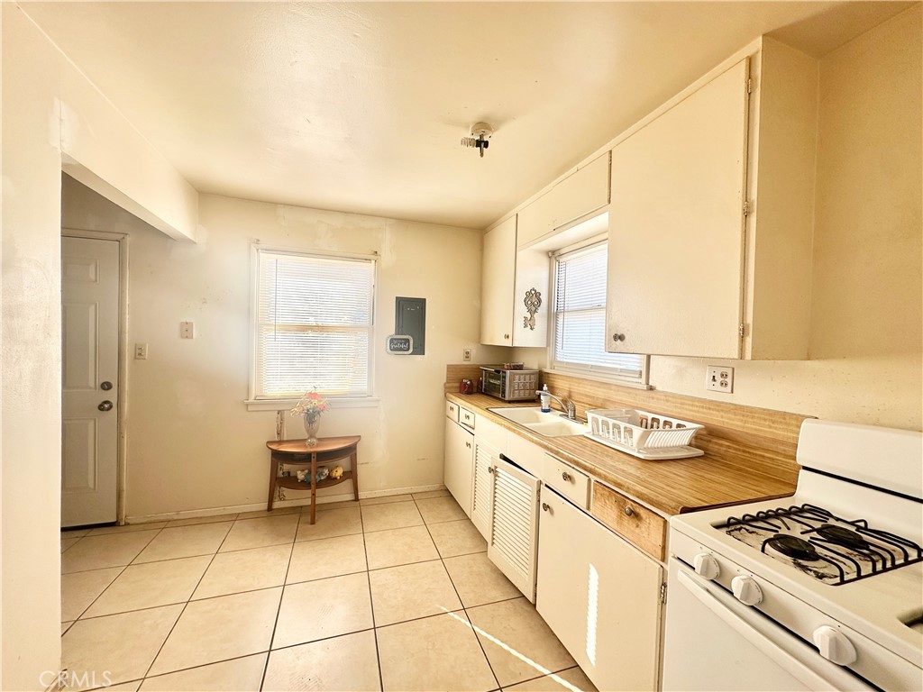 82038 5th Street Trona, CA 93562 - Photo 8 of 21 a kitchen with a stove a sink and a refrigerator