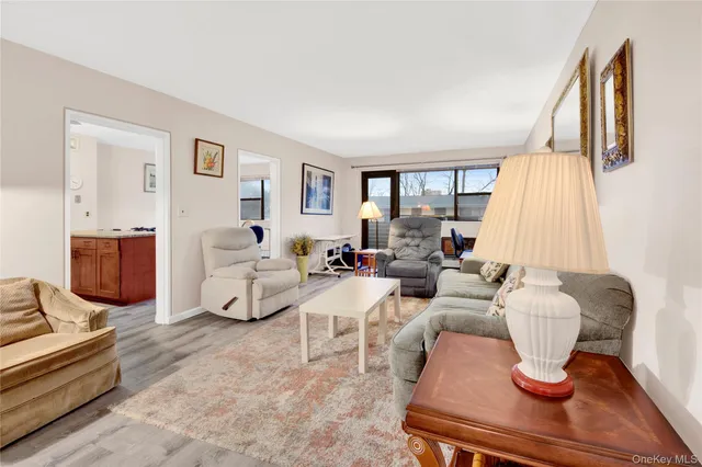 a open kitchen with stainless steel appliances granite countertop a stove top oven a sink a dining table and chairs with wooden floor