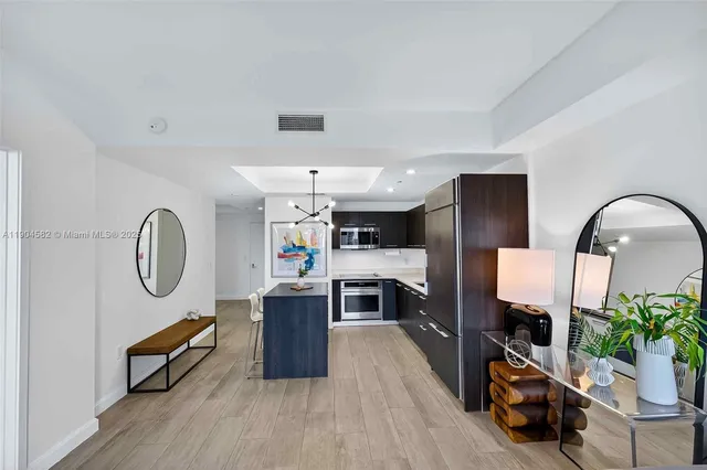 a kitchen with stainless steel appliances kitchen island granite countertop a refrigerator a sink and a stove