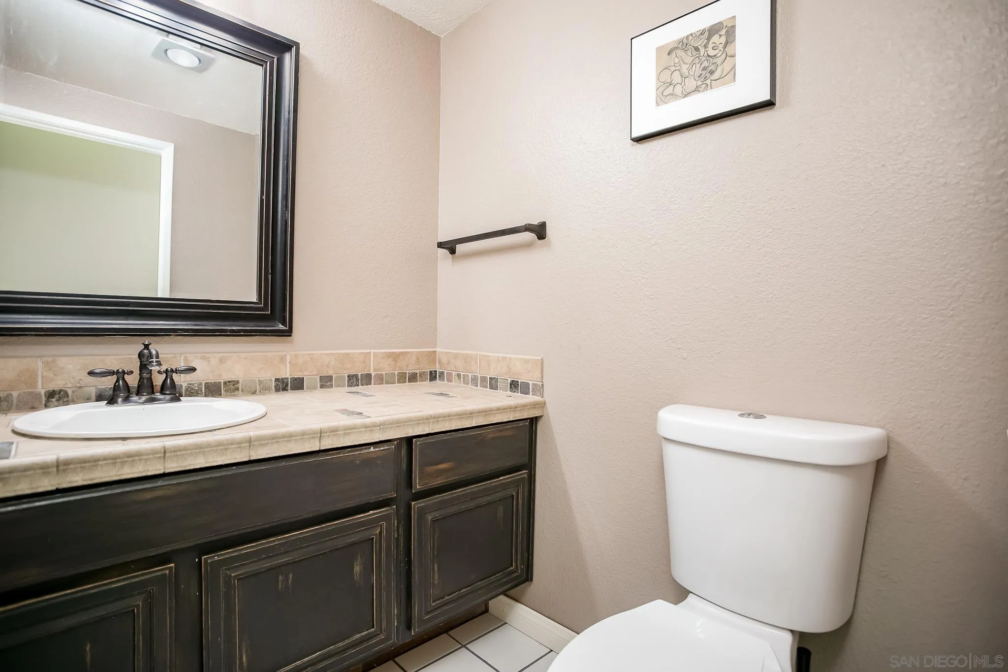 9229 Birchcrest Boulevard Santee, CA 92071 - Photo 29 of 39 a bathroom with a toilet a sink and mirror