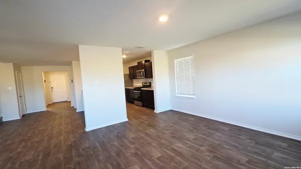 a view of a kitchen with wooden floor and a refrigerator