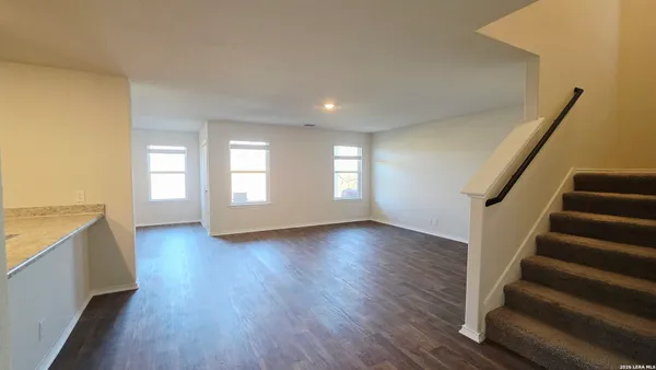 a view of an empty room with closet and a window