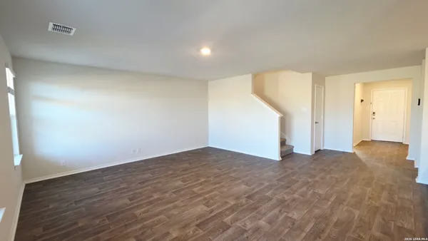 a view of an empty room and wooden floor
