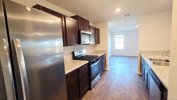 a kitchen with stainless steel appliances granite countertop a stove a sink and a refrigerator