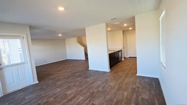 an empty room with wooden floor and a window