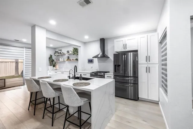 a kitchen with refrigerator and chairs