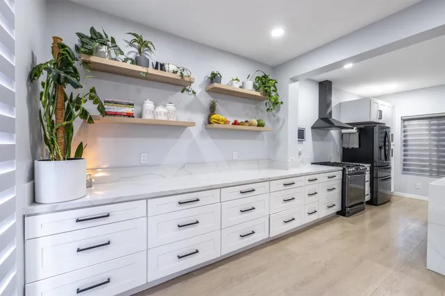 a kitchen with cabinets a window and potted plant