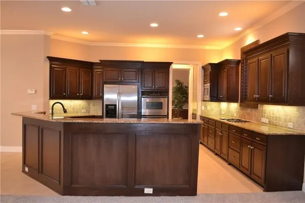 a kitchen with stainless steel appliances granite countertop a sink a stove and a refrigerator