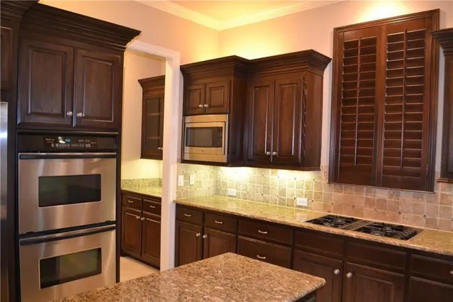 a kitchen with granite countertop wooden cabinets and stainless steel appliances