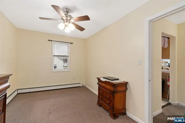 an empty room with windows and ceiling fan
