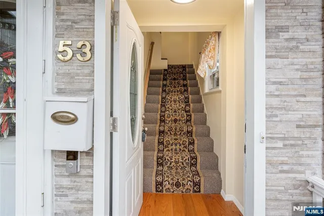 a view of a hallway with wooden floor and entryway