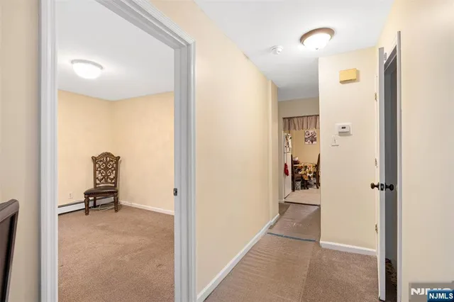 a view of a hallway with closet and a living room
