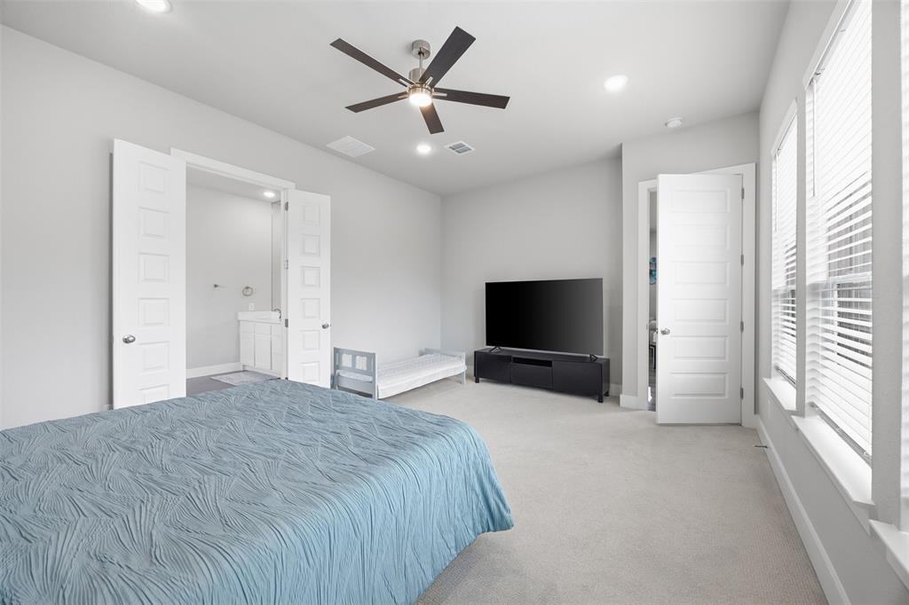 5805 Heatherwood Loop Sachse, TX 75048 - Photo 20 of 39 a bedroom with a bed and a flat screen tv
