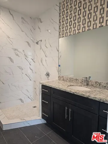 a bathroom with a granite countertop sink and a mirror