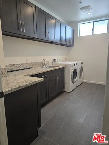a utility room with granite countertop cabinets washer and dryer