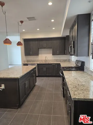 a large kitchen with granite countertop a sink and cabinets